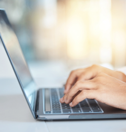 A person is typing on a laptop's keyboard, searching for jobs in Dubai. This image represents the ease of finding a job in Dubai through online platforms.